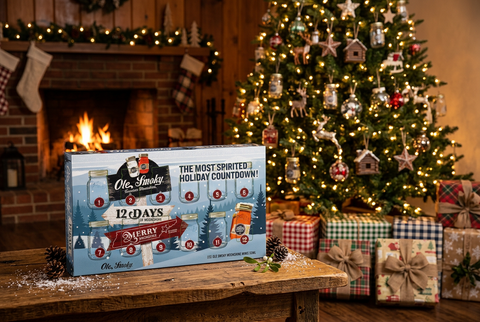 Ole Smoky 12 Days of Moonshine advent calendar gift by a fireplace and Christmas tree